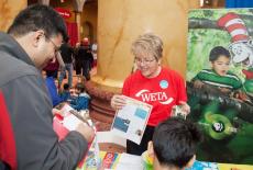 WETA Volunteer talks to guests at an event.