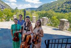 August 20, 2022, St. Peter’s Chapel, Harpers Ferry, WV From left, Danielle Wiebe Burke (viola), Sam Suggs (bass), Katie Tertell (artistic director and cello), and Rachelle Hunt (violin) pause before a concert in St. Peter’s Chapel’s courtyard overlooking the beautiful landscape surrounding Harpers Ferry, WV. 