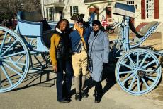 two women and a man in front of a horse and carriage