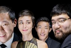 The quartet is upclose in this image, all their faces are close together and smiling in front of a black background. 