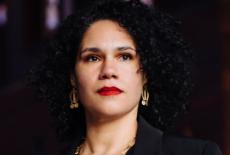 A headshot of composer Jessie Montgomery, wearing a black top and gazing upwards