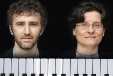 Sam and Ralitzas heads are peaking over a piano keyboard