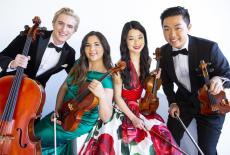 The Viano Quartet poses playfully together, men in tuxedo, women in brightly colored dress.