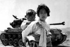 Girl in front of tank with brother on her back