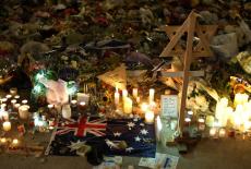 An Australian flag sits amongst floral tributes honouring the victims of a shooting at Jewish holiday celebration on Sunda...