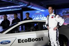 Driver Biffle poses for photographs in front of the new 2013 Ford stock car after an announcement during the NASCAR Media ...