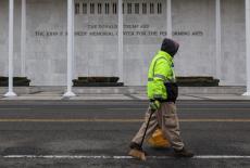 A worker walks in front of the recently renamed Donald J. Trump and John F. Kennedy Memorial Center for the Performing Art...