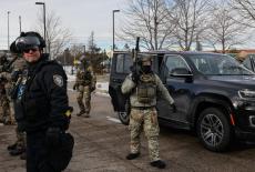 An ICE vehicle is blocked by demonstrators outside the Bishop Henry Whipple Federal Building during a protest against incr...