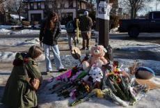 People stand by a makeshift memorial at the scene of the fatal shooting of Renee Nicole Good by a U.S. Immigration and Cus...