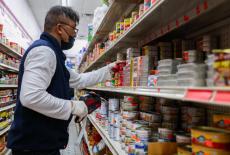 A Sun Vin Grocery employee adds price tags and stocks shelves in Chinatown in New York