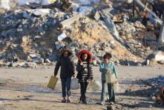 Palestinian girls walk past the rubble of residential buildings destroyed during the war, in Gaza City