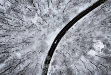 A drone view of a car driving through the snow covered woods of Blauvelt State Park after a winter storm bore down on the ...