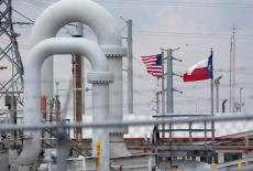 FILE PHOTO: FILE PHOTO: A maze of crude oil pipe and equipment is seen with the American and Texas flags flying during a t...
