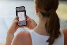 FILE PHOTO: A teenager poses holding a mobile phone displaying a message from TikTok in Sydney