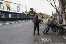A member of a police force stands guard on a street, amid the U.S.-Israeli conflict with Iran, in Tehran