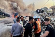Palestinians inspect the site of what medics said was an Israeli airstrike on a car near the entrance to Zawayda town