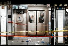 Commuters in a train pass near the crime scene where three people were attacked inside the subway system at Grand Central ...