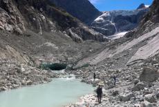 Hikers walk on the moraine at the Mont Mine glacier near Evolene