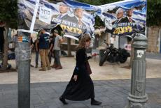 A woman passes by a banner depicting Israeli Prime Minister Benjamin Netanyahu and US President Donald Trump day after the...