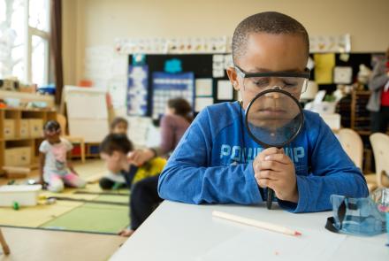 Kindergarten boy with magnifying glass