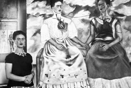 Frida Kahlo pictured with her oil painting