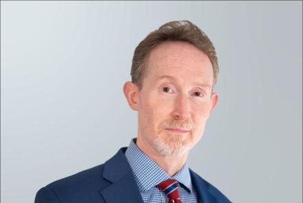 Evan Keely wearing blue suit and tie