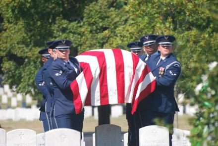 Air Force Honor Guard pallbearers carry casket to burial site.