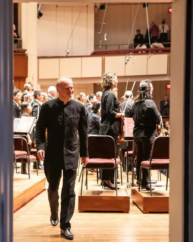 Maestro Noseda walking off stage, Charles Lawson's microphones hanging above.