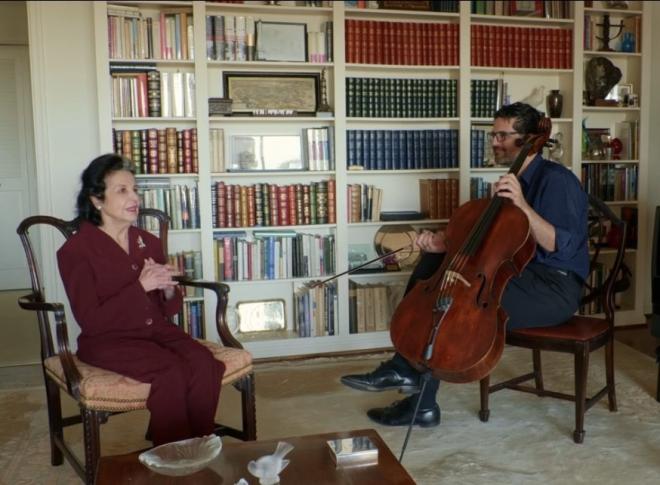 Amit sits with Marta Casals Istomin while holding Pablo Casals cello