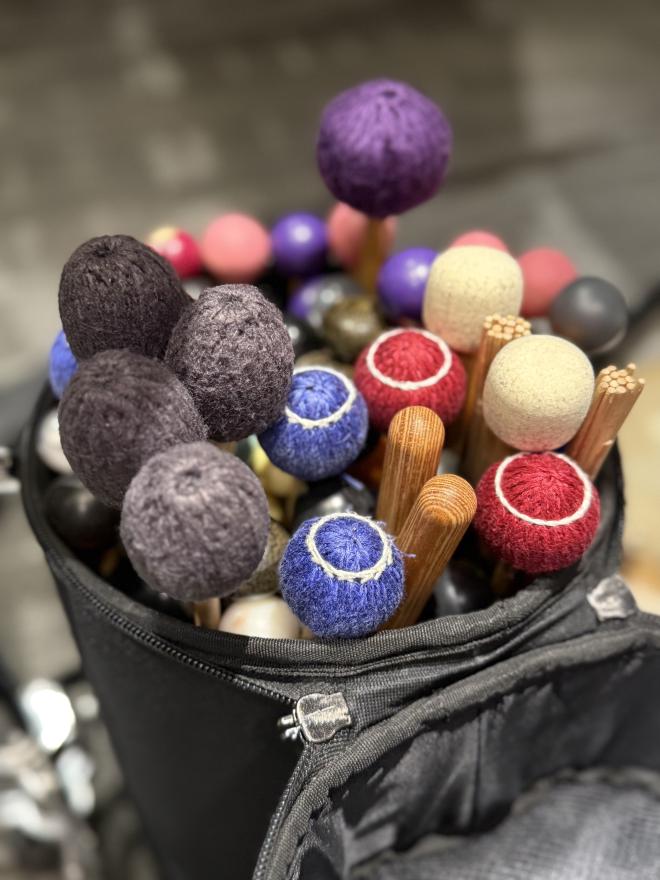 An open mallet bag with a wide selection of colorful percussion mallets
